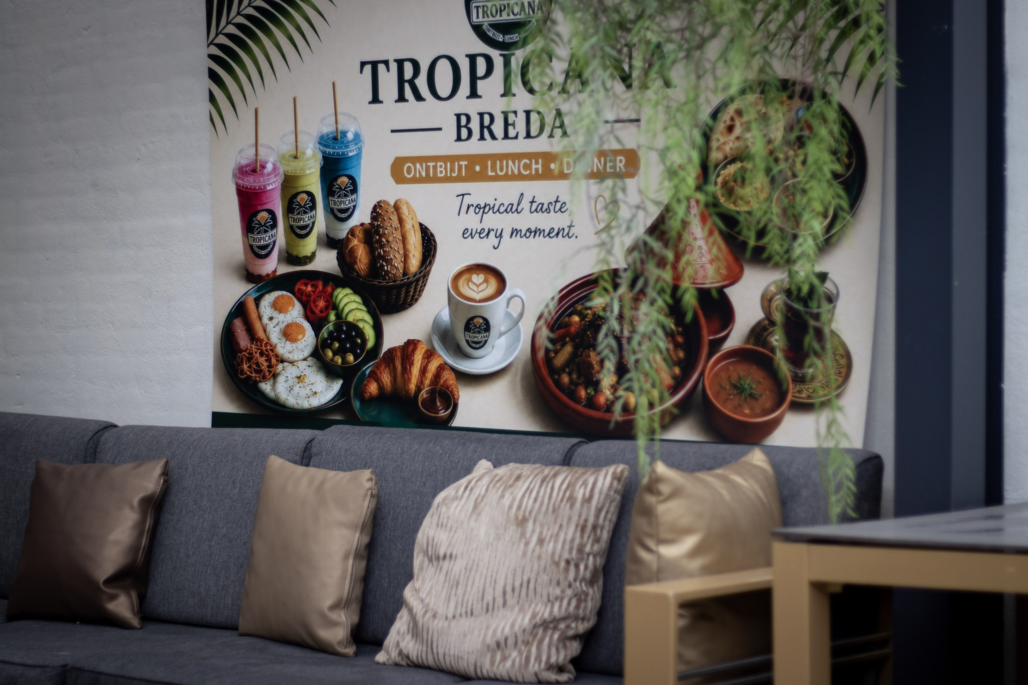 Lounge van Tropicana Breda met menuwand, logo en zitbank