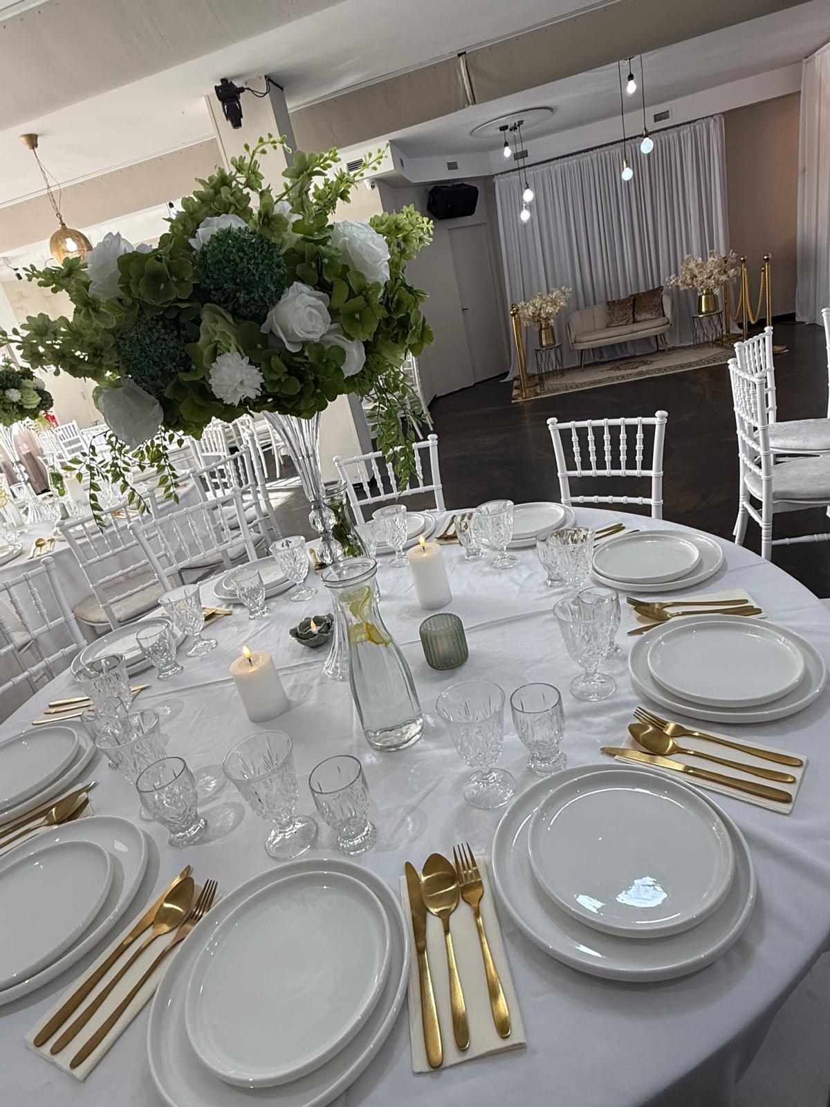 Luxe tafelsetting met trouwdecoratie op de achtergrond bij Tropicana Breda