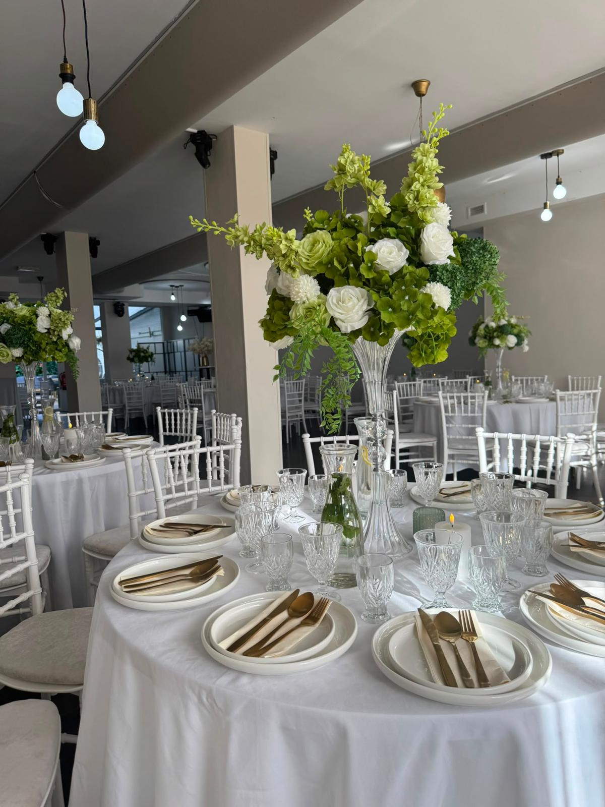 Detail van tafeldecoratie met groen-wit bloemstuk in de feestzaal van Tropicana Breda